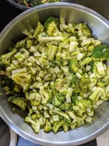 A bowl of chopped, cooked broccoli illustrating the use of organic vegetables in healthy homemade dog food recipes.