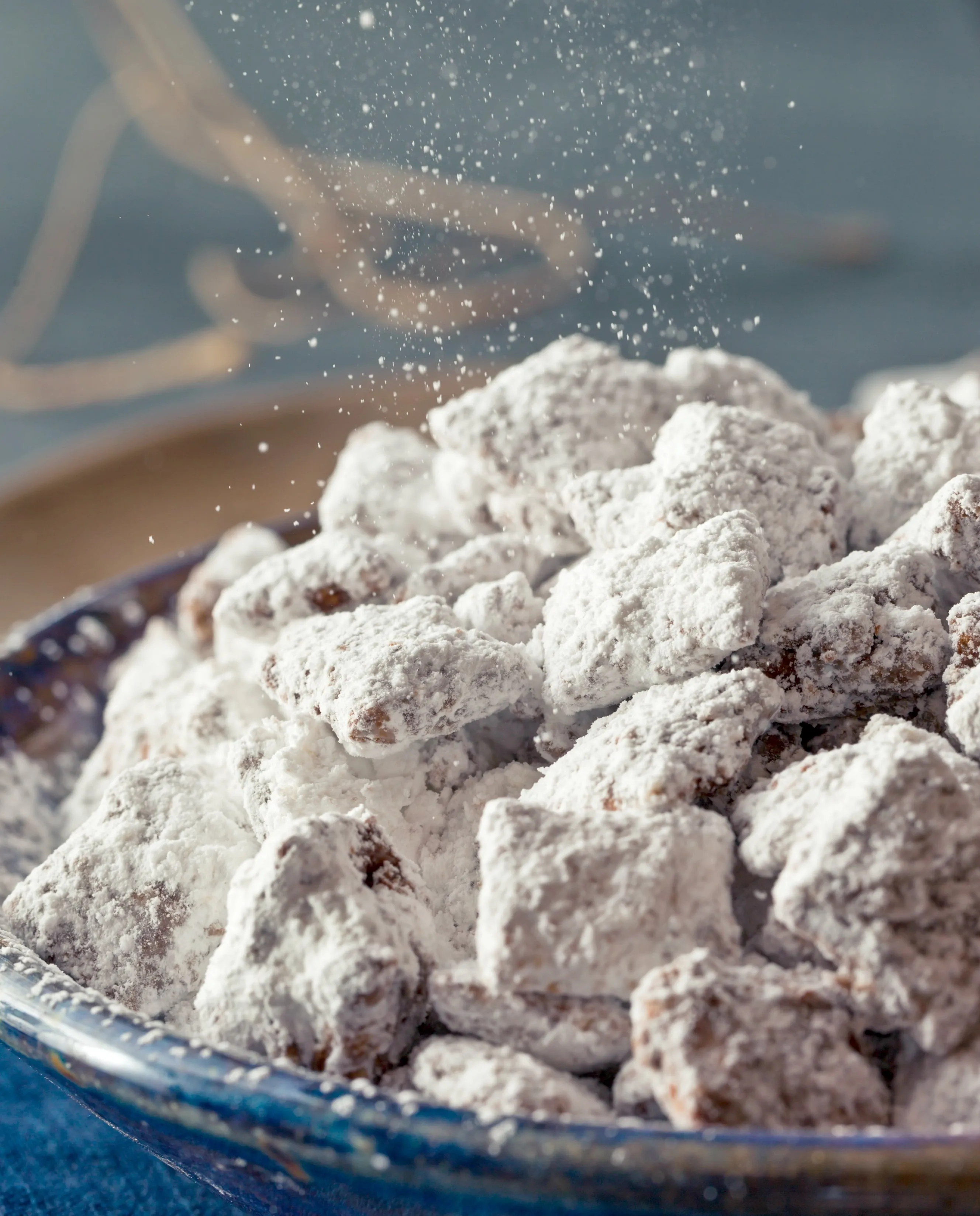 A bowl of human 'Puppy Chow' snack, also known as Muddy Buddies, made with Chex cereal, peanut butter, chocolate, and powdered sugar, highlighting its misleading appearance.