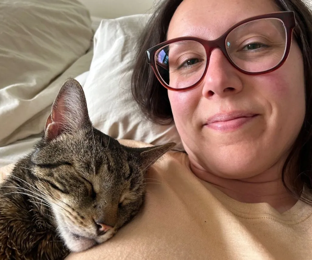 A content cat, Jericho, cuddling with his owner, exemplifying a happy feline in a well-cared-for home environment.