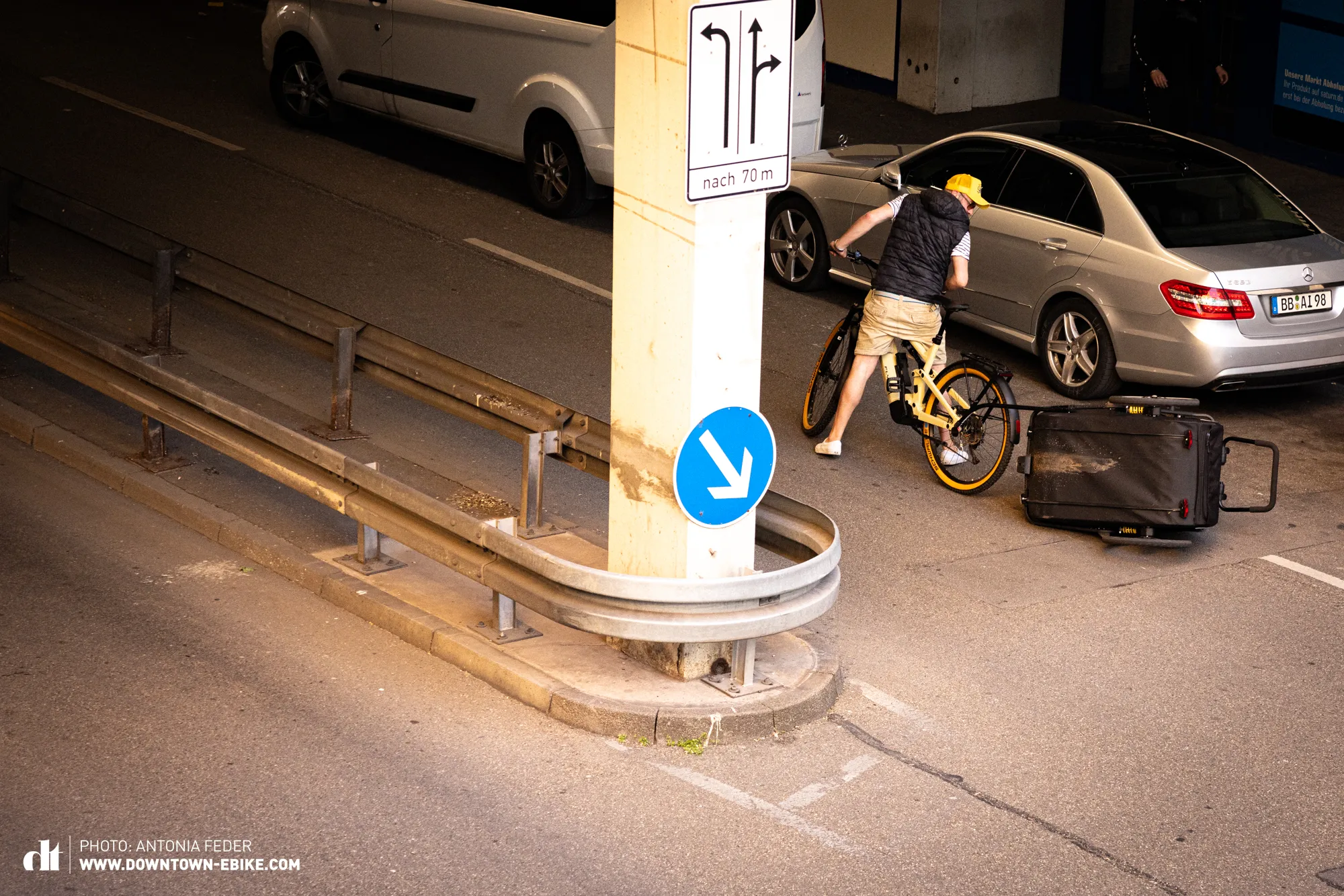 A dog bike trailer is shown tilting dangerously while in motion.