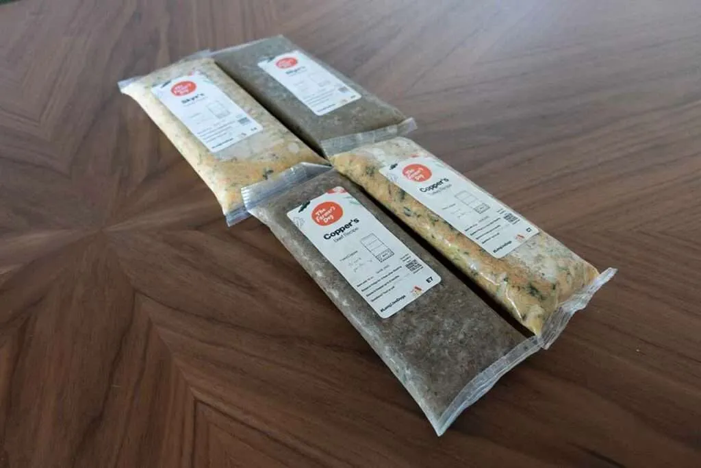 A dog looking at a bowl of The Farmer's Dog food, highlighting the premium nature