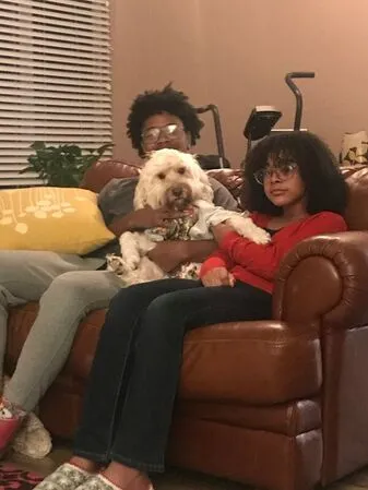 A Labradoodle named Annie happily posing with her family, showcasing her loving nature.