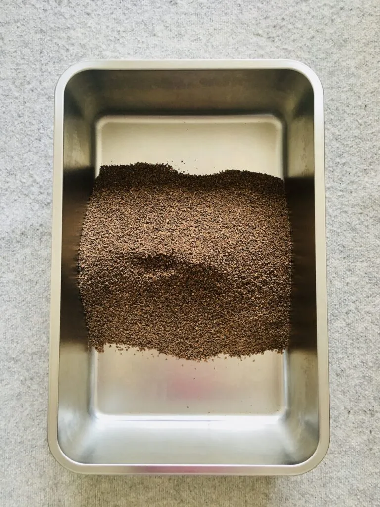 A sparkling clean stainless steel litter box filled with walnut litter, ready to be placed inside a stylish chewy cat litter box furniture enclosure.