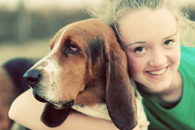 Alex affectionately interacting with Charlie the Basset Hound on the ranch porch.