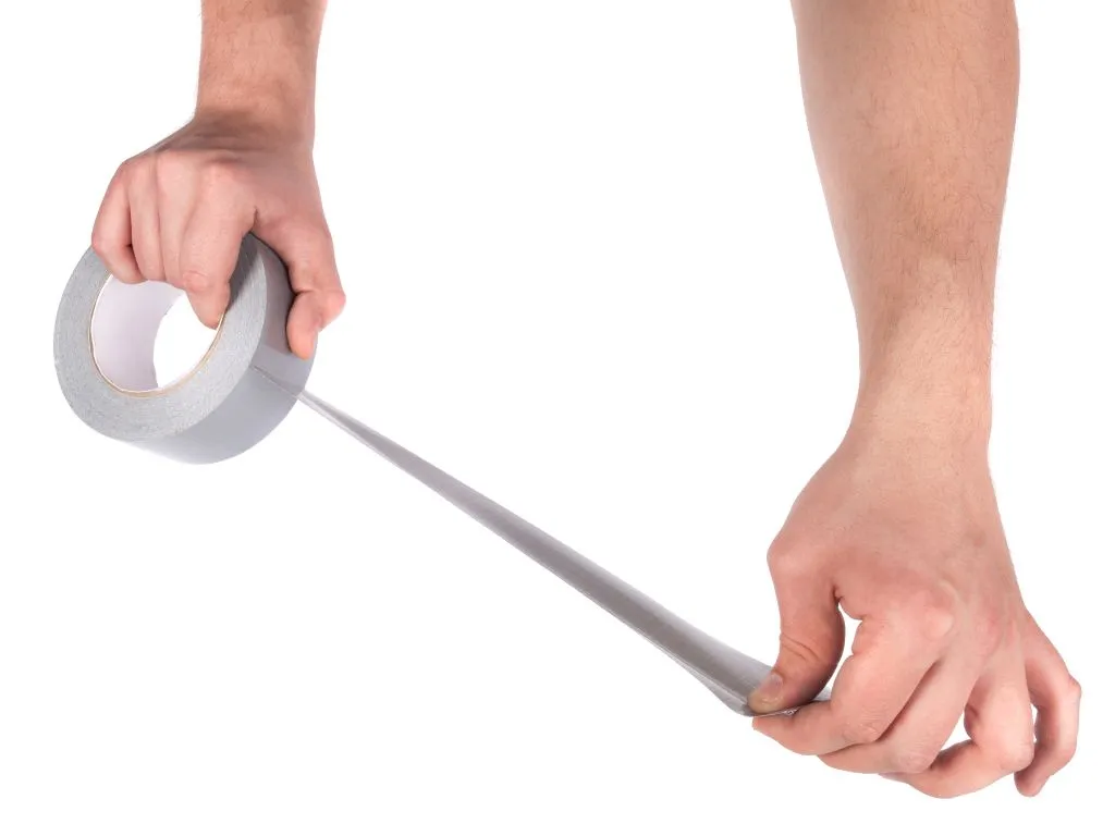 Applying duct tape to car seat to lift dog hair, a popular trick for getting dog hair out of car carpet