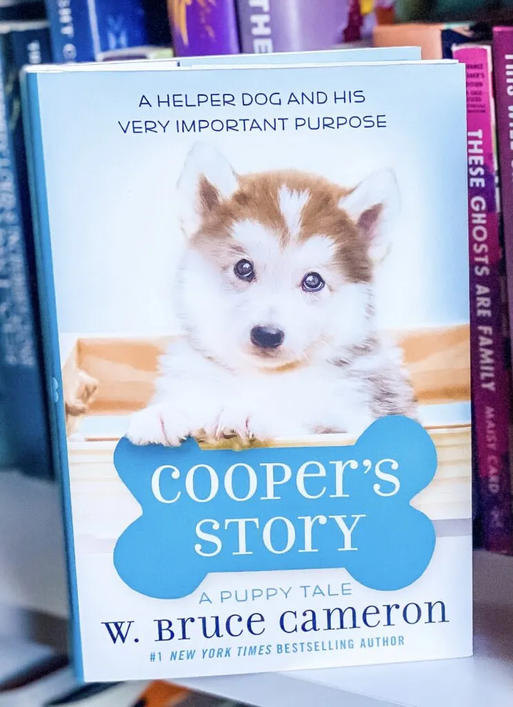 Book cover of Cooper's Story: A Puppy Tale by W. Bruce Cameron, showing a service dog next to a boy in a wheelchair