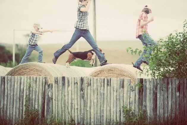 Children and cousins gathering around Charlie the Ranch Dog, showering him with affection.