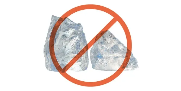 Clear ice cubes in a glass, representing frozen treats that can be too hard and damaging for dog's teeth.