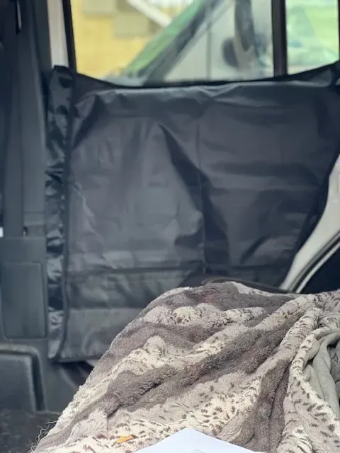 Close-up of a DIY or store-bought dog car door protector featuring storage pockets, installed to prevent dog scratches and drool