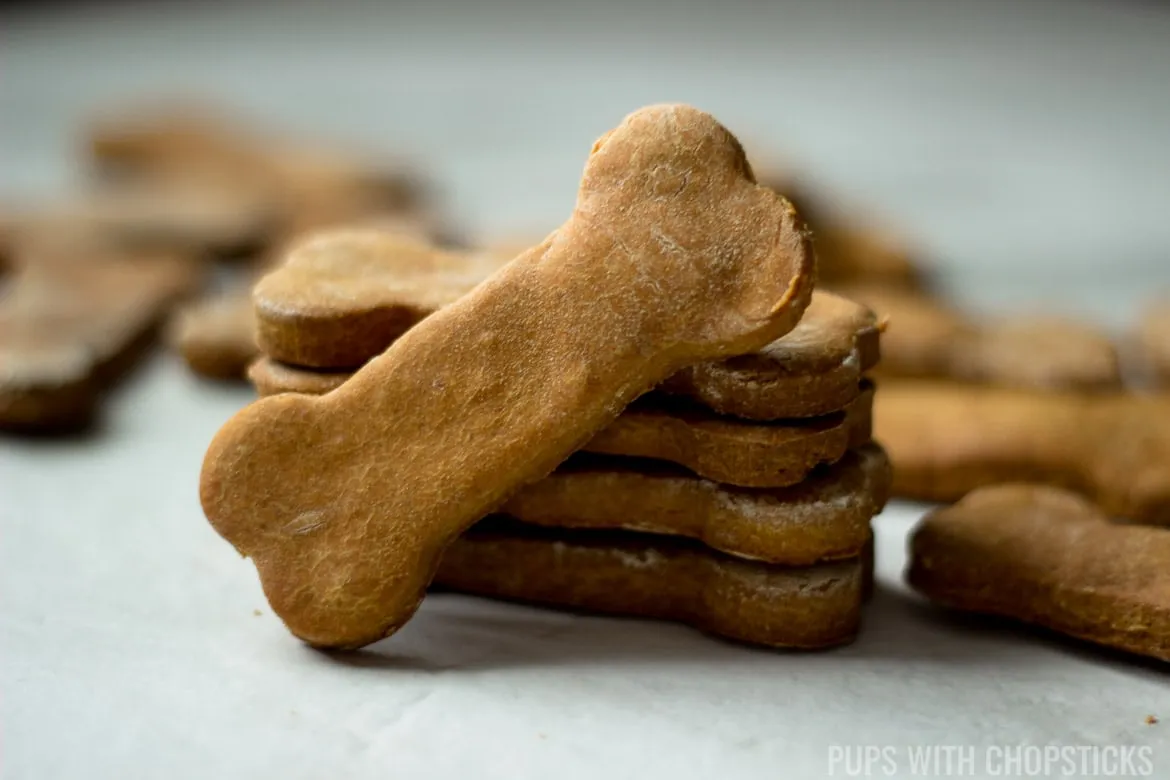 Close-up view of freshly baked grain-free pumpkin peanut butter dog treats, showcasing their golden brown color and texture.