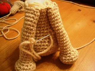 Crocheted Amigurumi Teacup Yorkie standing, side profile, showing its dark brown body and lighter head.