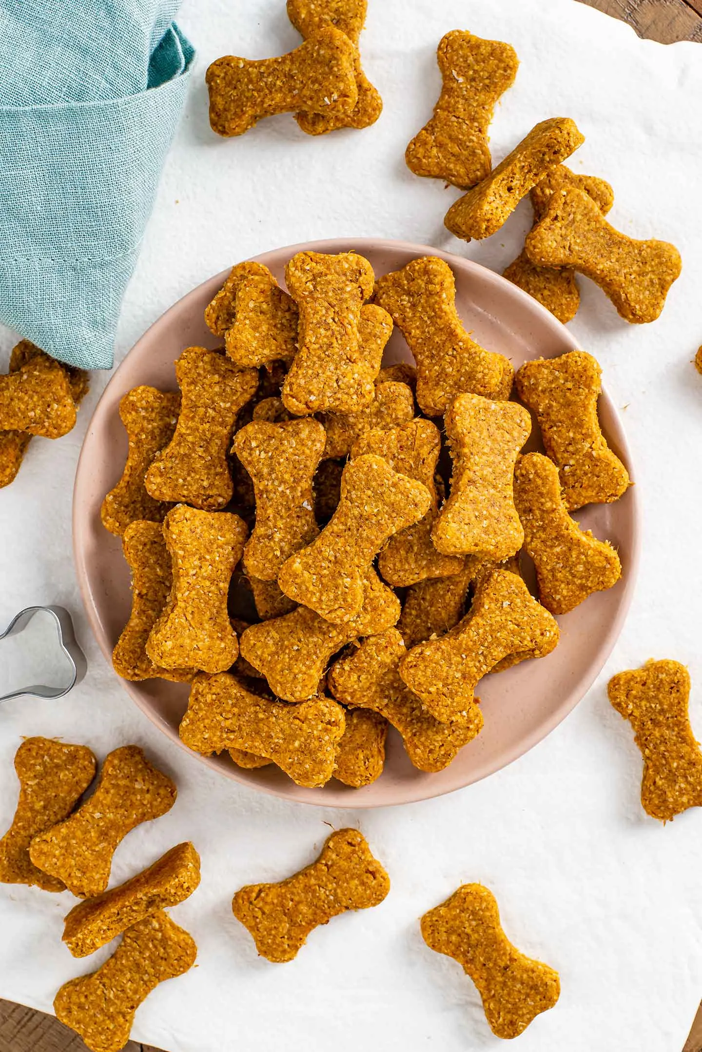 Delicious golden-brown dog bone treats on a white plate, showcasing a healthy homemade snack.
