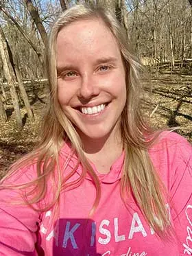 Emma Blauw stands proudly with her black tri Australian Shepherd, Banjo, the heroic dog who saved her life.