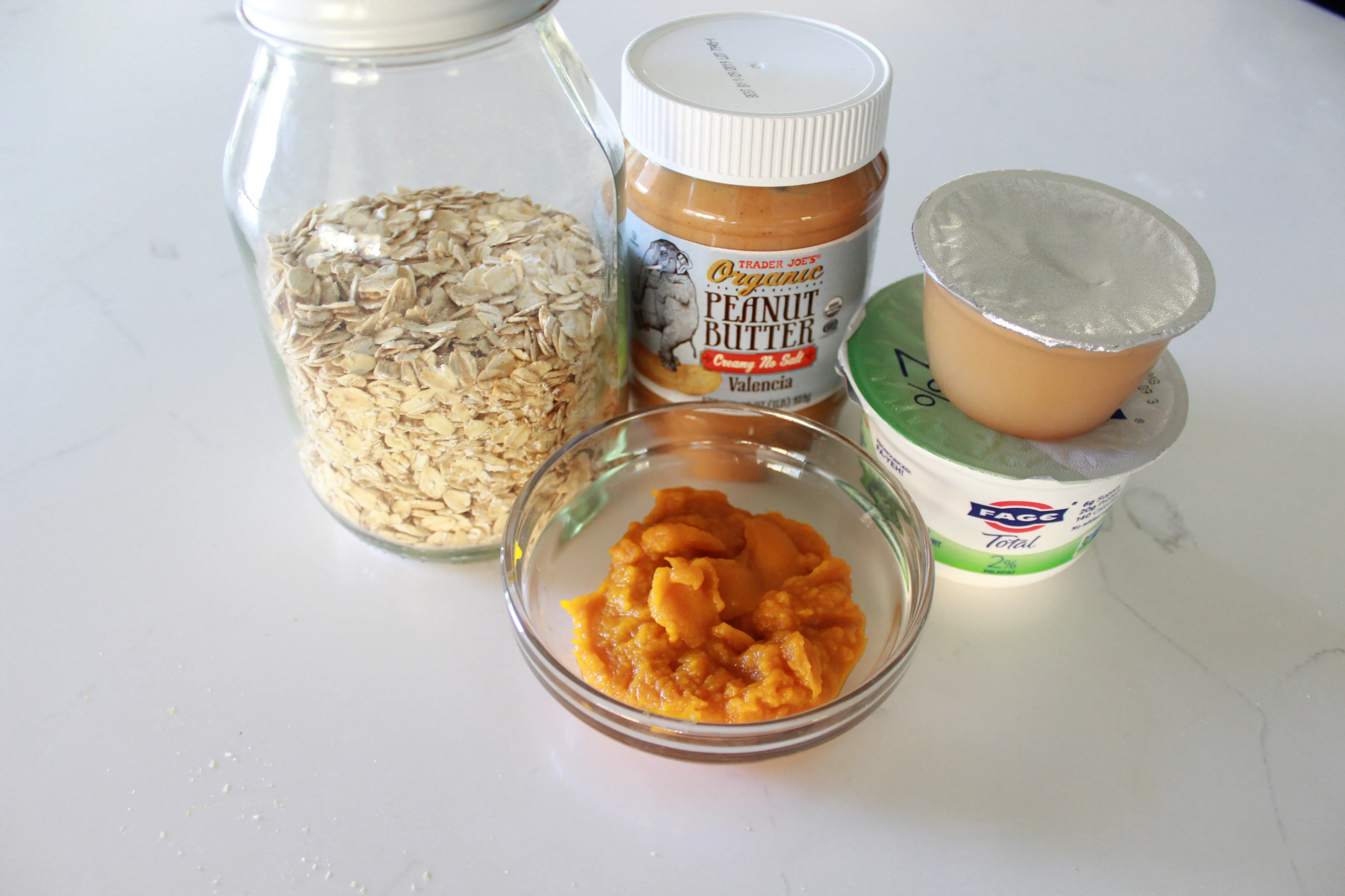 Essential ingredients for homemade soft dog treats no bake, including pumpkin puree, applesauce, peanut butter, yogurt, and old-fashioned oats.