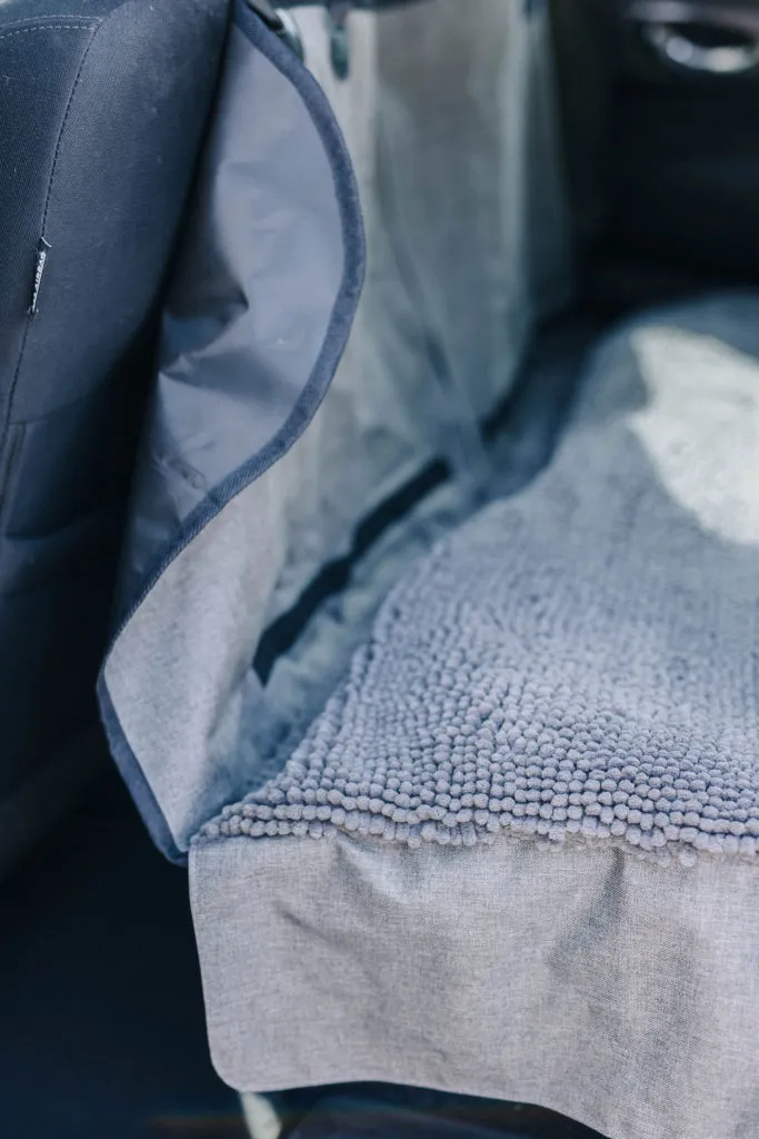 Examining the Dirty Dog microfiber material, showcasing the soft texture of the DGS Pet car seat protector.