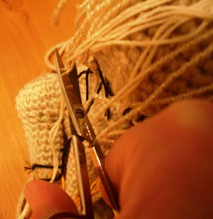 Finished crocheted Amigurumi Teacup Yorkie with a small pink bow on its head, sitting upright.