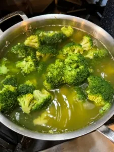 Fresh green broccoli being boiled for a nutritious home cooked dog meal
