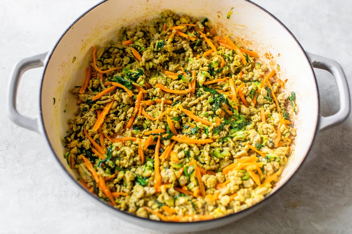 fresh veggies added to browned ground turkey in a large pot.