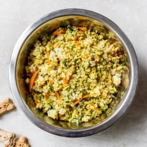 Homemade dog food in a metal dish.
