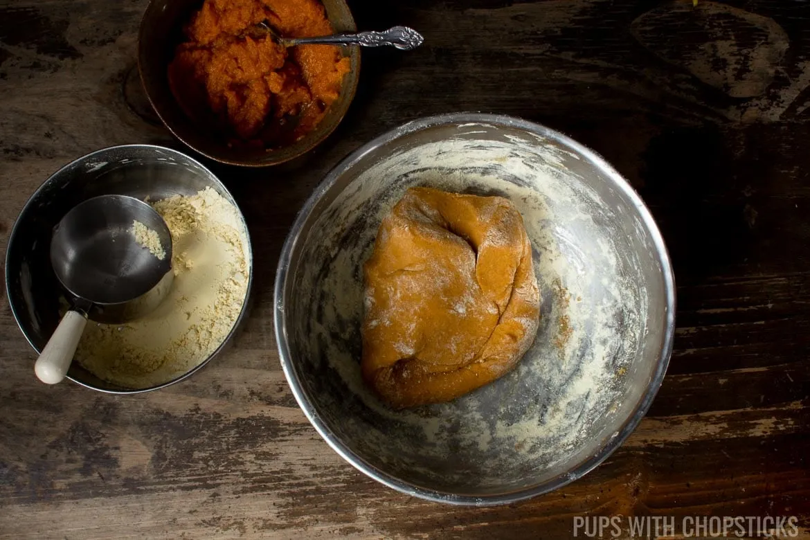 Homemade grain-free pumpkin dog treat dough in a mixing bowl, demonstrating the ideal play-doh consistency before shaping.