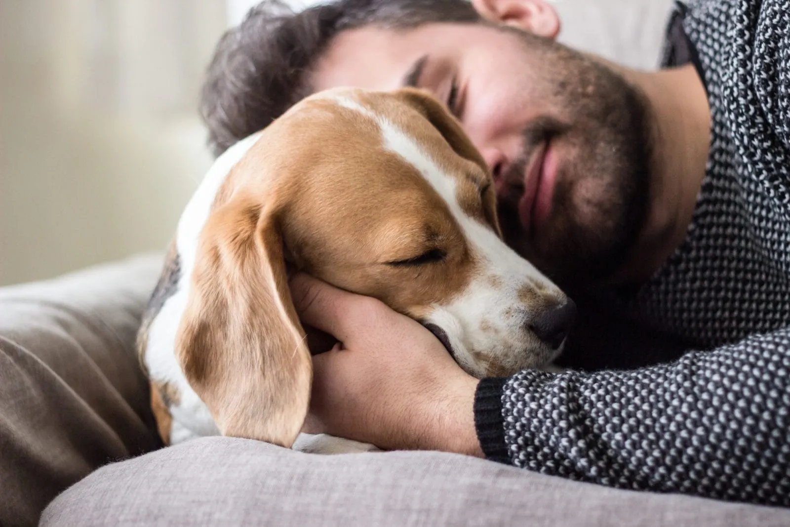 Man resting and cradling dog