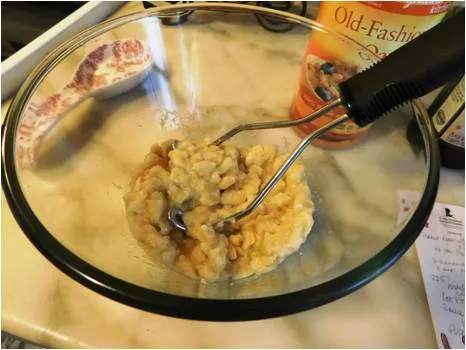 Mashing bananas with a potato masher.