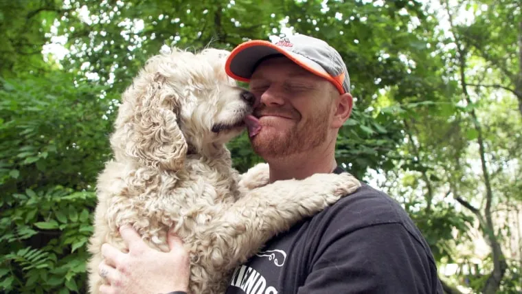 Mason Taylor embracing Mack, a blind senior dog thriving at Old Friends Senior Dog Rescue
