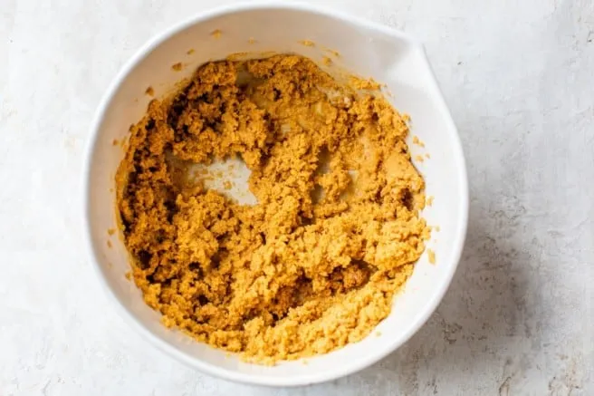 mixing almond flour in with peanut butter mixture in a medium bowl