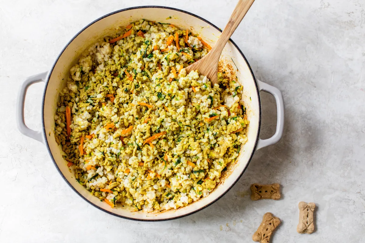 Mixing cooked vegetables and turkey with an egg for homemade dog food