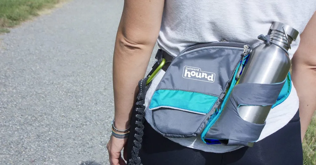 Outward Hound Hipster Bottle Holder and Dog Treat Pouch worn by an owner, essential accessories for hydrating and rewarding pets on adventures.