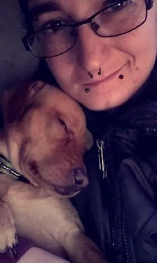 Professional dog sitter interacting with a happy dog in a natural setting, representing a trusted dog sitting agency.