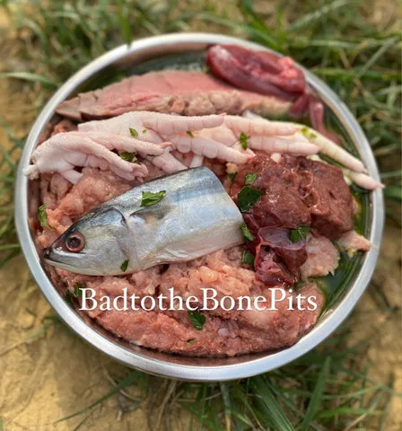 Raw chicken and organ meat meal with fish, chicken feet, and vegetables for Pitbulls