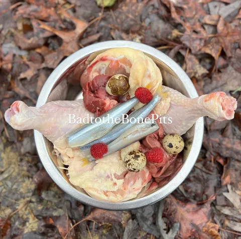 Raw chicken leg quarters, smelt, beef kidney, chicken liver, raspberries, and quail eggs, a balanced meal for Pitbulls