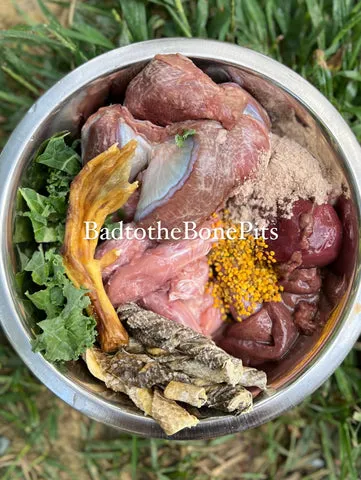 Raw chicken necks and turkey gizzards meal for Pitbull with duck foot, kale, and fish skin
