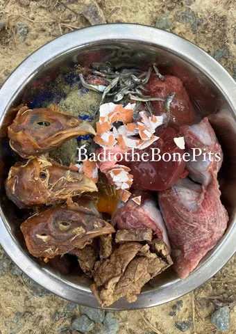 Raw ground beef meal for Pitbull with chicken heads, egg, various organs, kelp, and spirulina