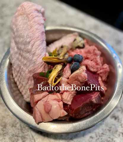 Raw pork and turkey wing meal for Pitbull with beef heart, liver, quail eggs, and berries