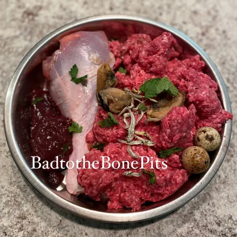 Raw turkey drumstick and ground beef meal for Pitbull with quail eggs and fresh herbs