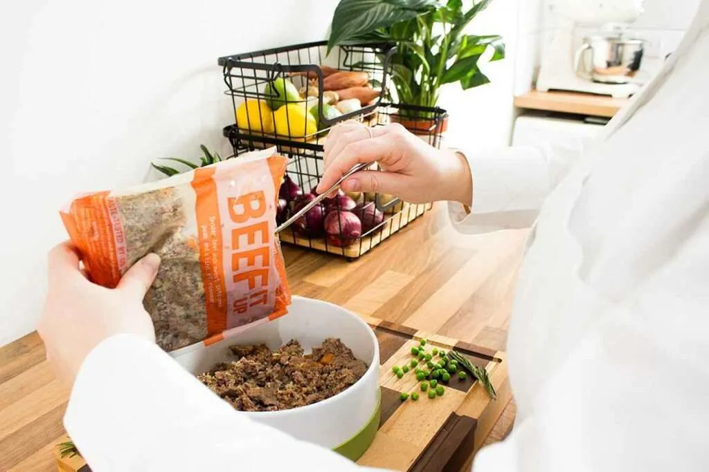 Serving Beef It Up Butternut Box recipe directly into a dog's bowl