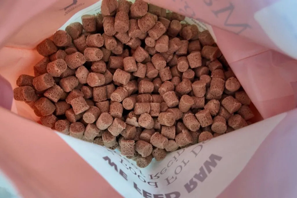 Stacked We Feed Raw frozen meal packets in a freezer drawer