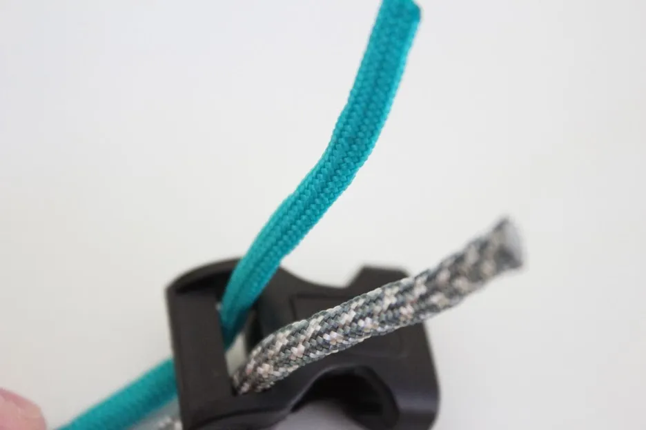The paracord ends are pulled back through the loop to secure them to the buckle.