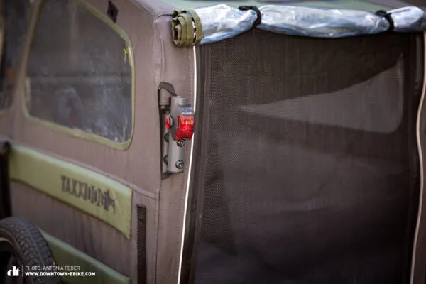 The TAXXI DOG bike trailer displays its rear light and mounting option, enhancing road safety.