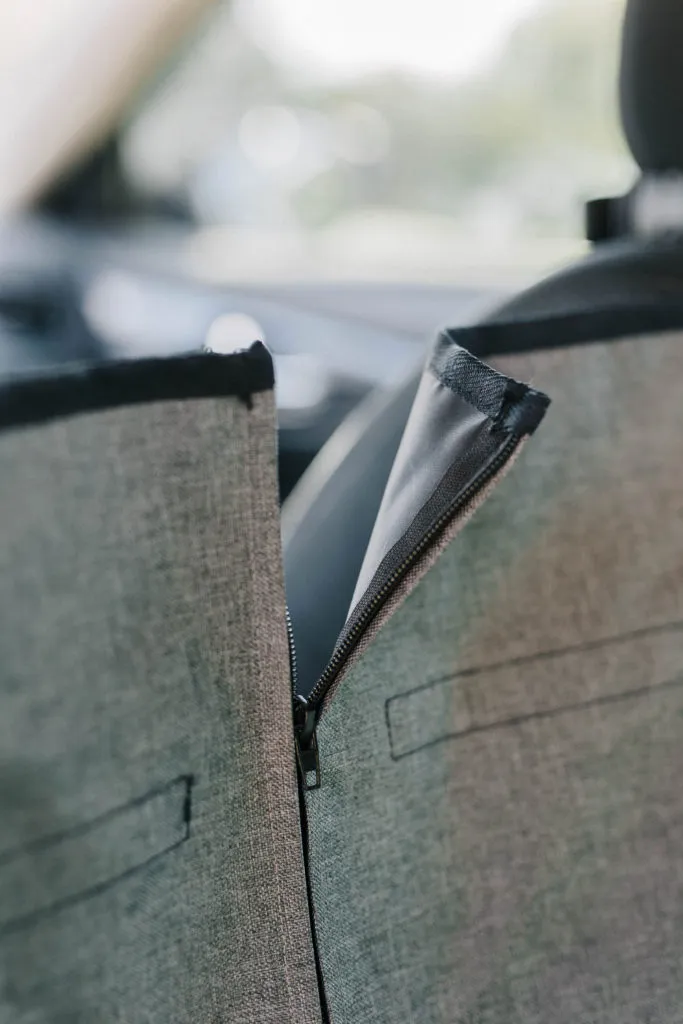 The zippered split feature on the DGS Pet dog car seat cover, demonstrating its half-hammock versatility.