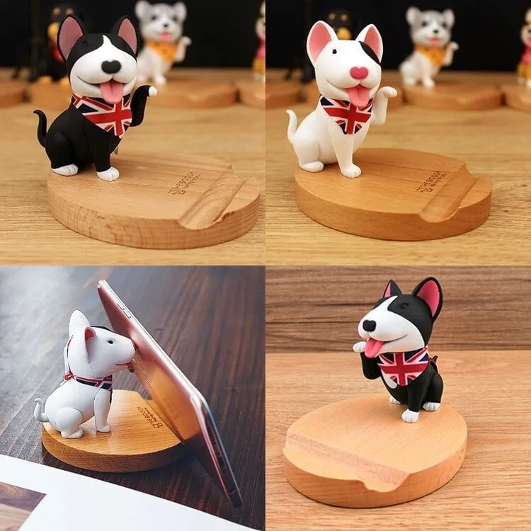 Two Bull Terrier phone holders on a wooden platform in the shape of black and white Bull Terrier dogs.