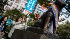 Visitors admiring the iconic Hachiko statue at Shibuya Crossing, a popular meeting spot and tribute to the devoted dog.