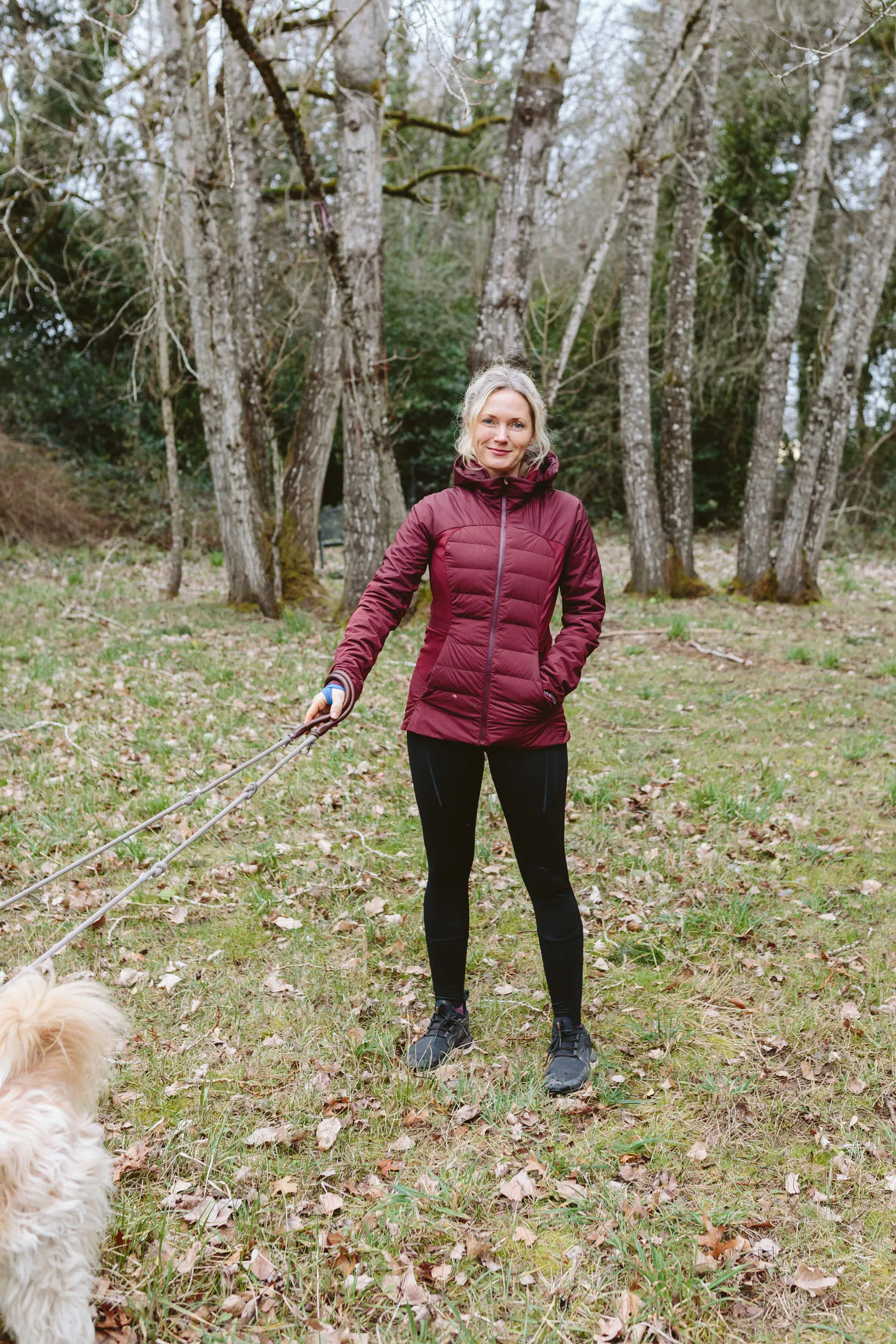 Woman in a dark, mid-length fitted jacket suitable for brisk walks in moderate cold.