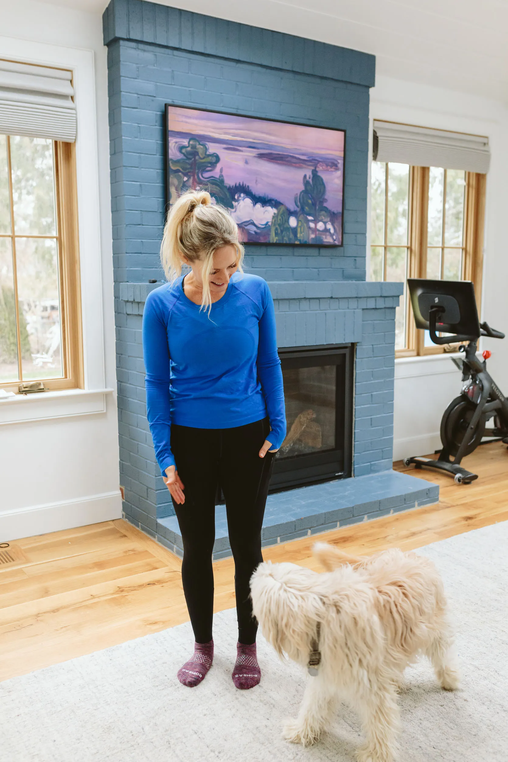 Woman in a long-sleeve base layer top with finger holes and high-performance leggings.
