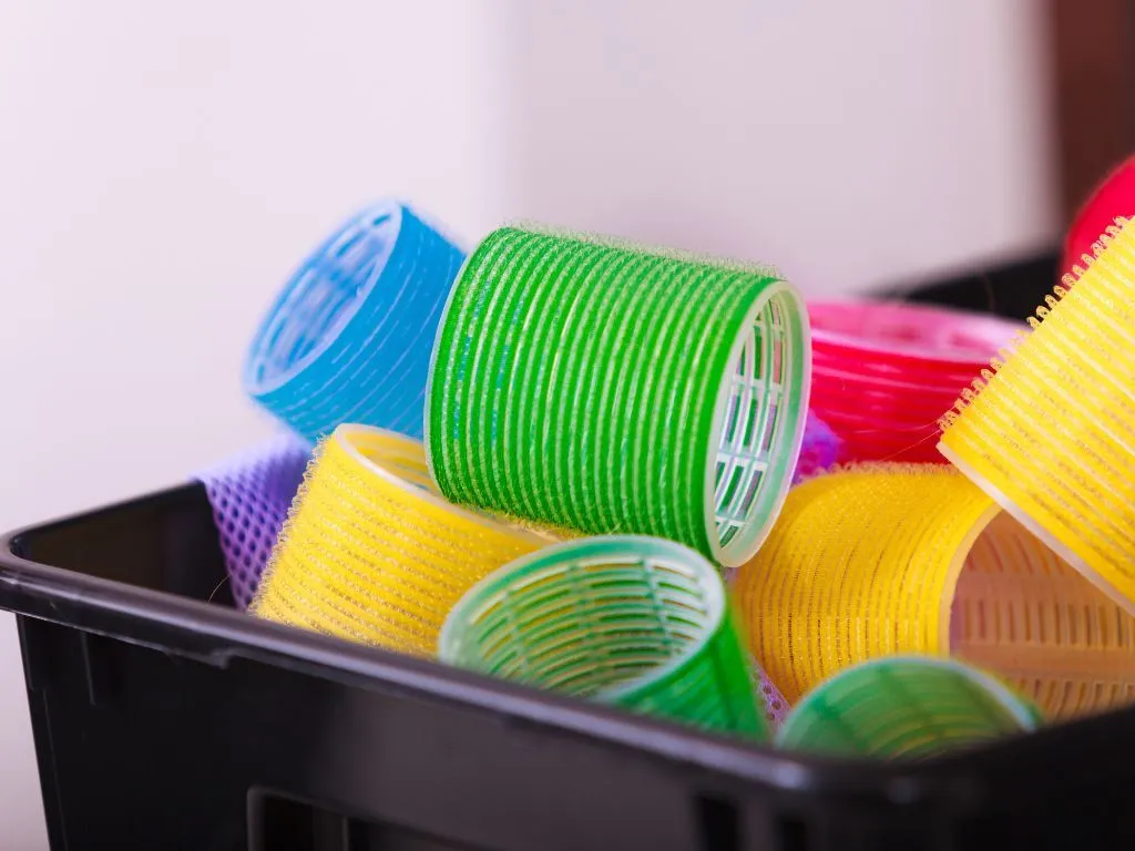 Woman using a velcro hair curler to remove dog hair from a car seat