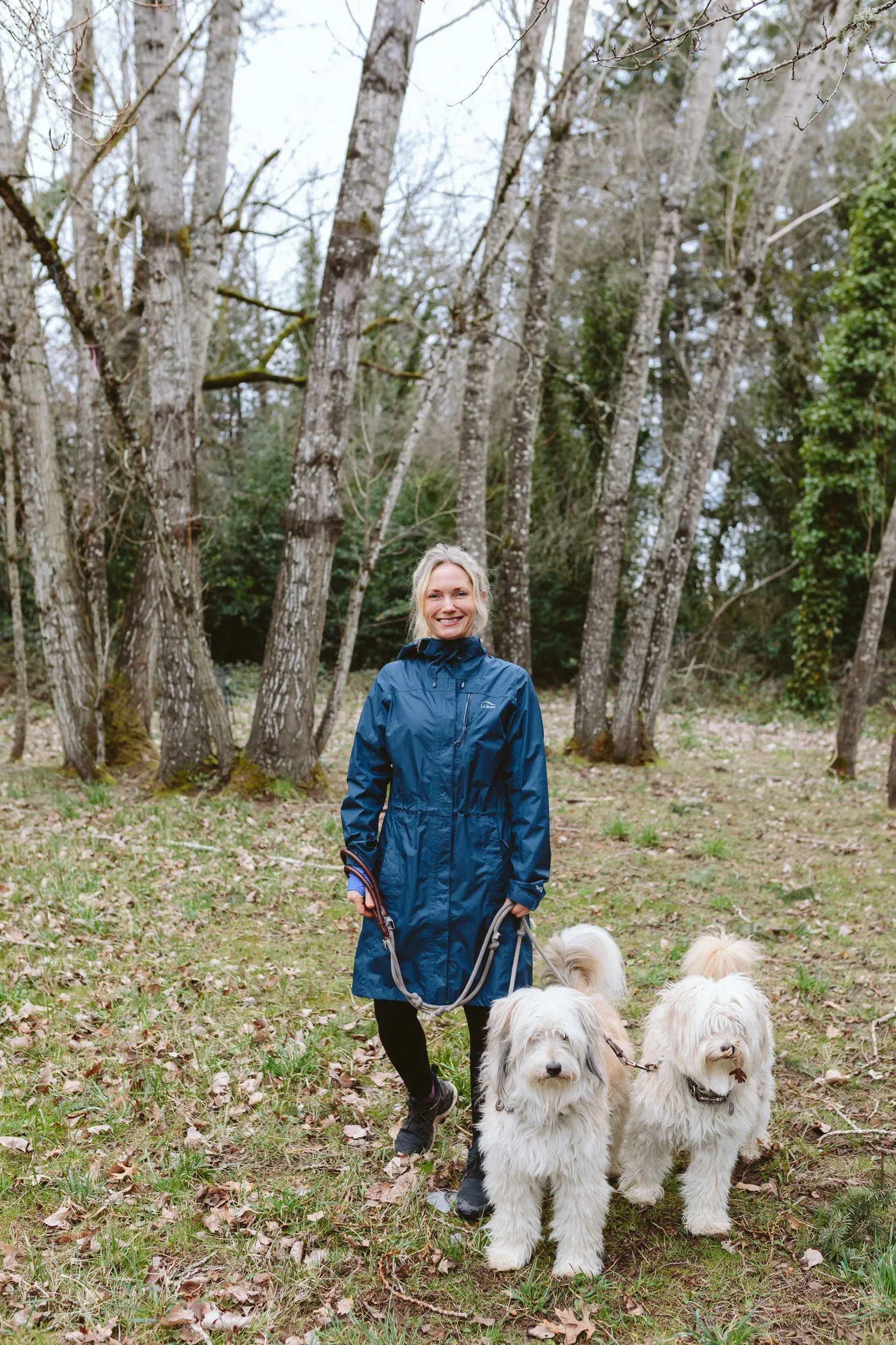Woman wearing a long, knee-length raincoat or windbreaker for wet weather.