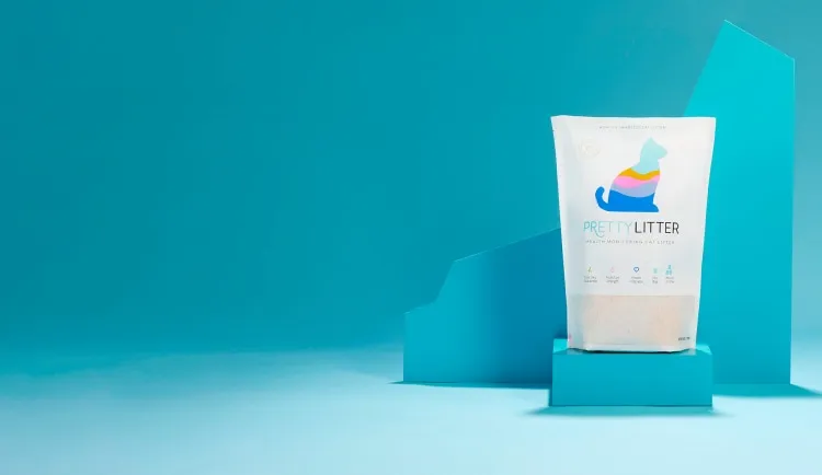 A bag of cat litter on display with blue geometric shapes in the background