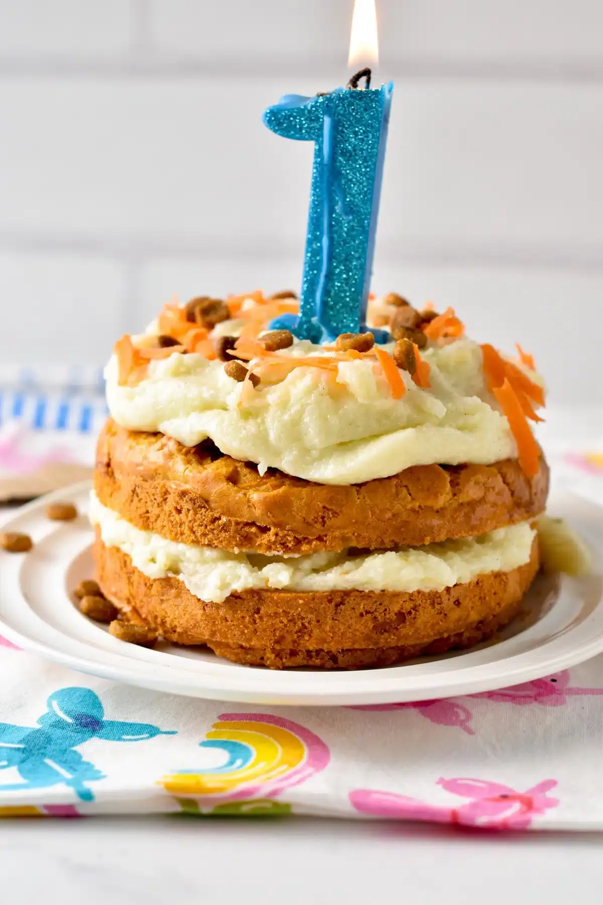 A beautiful no-bake dog cake with creamy frosting, garnished with shredded carrots and crunchy dog treats.